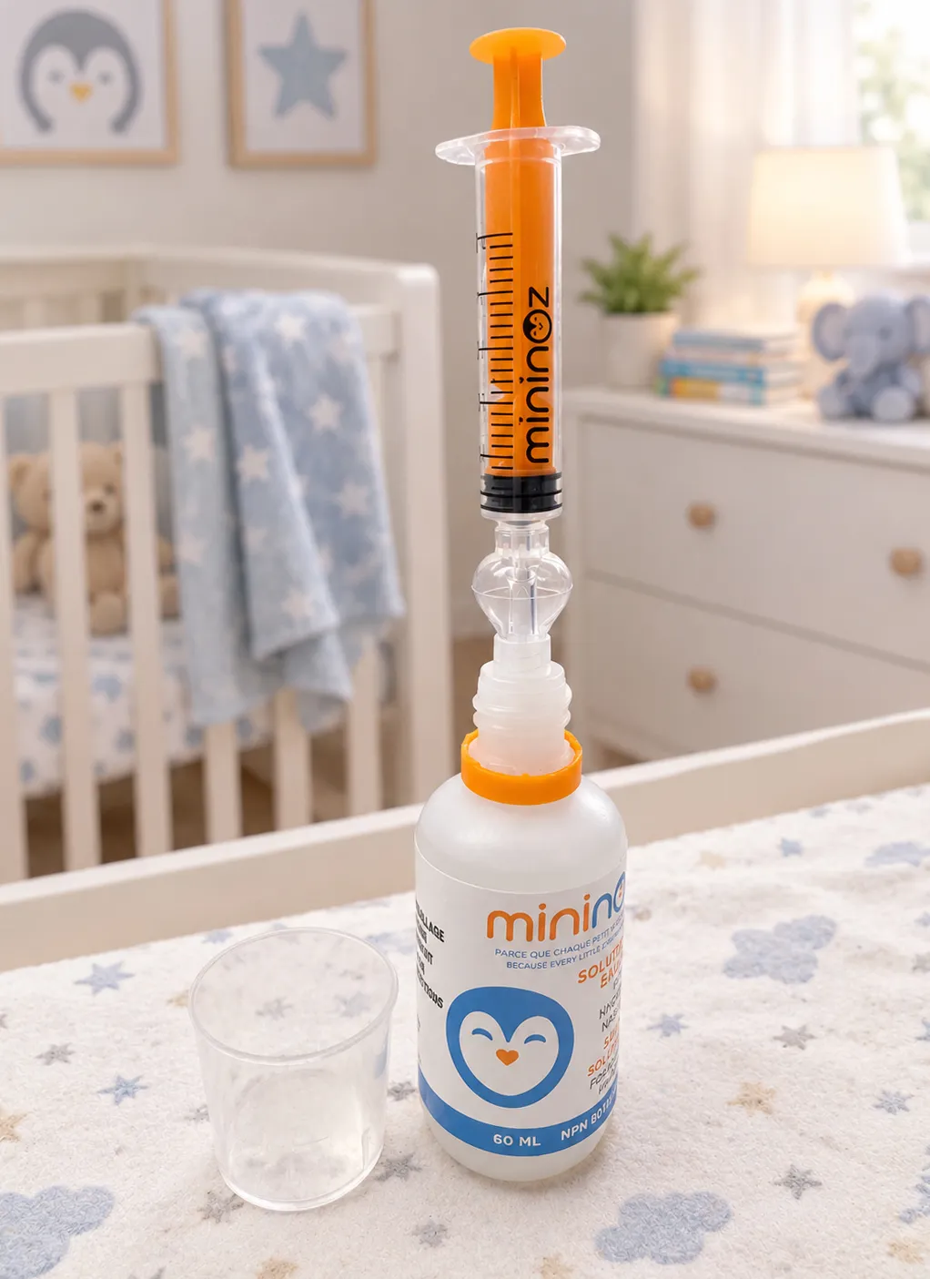 Seringue Mininoz fixée sur le flacon de solution saline, à côté d'un gobelet